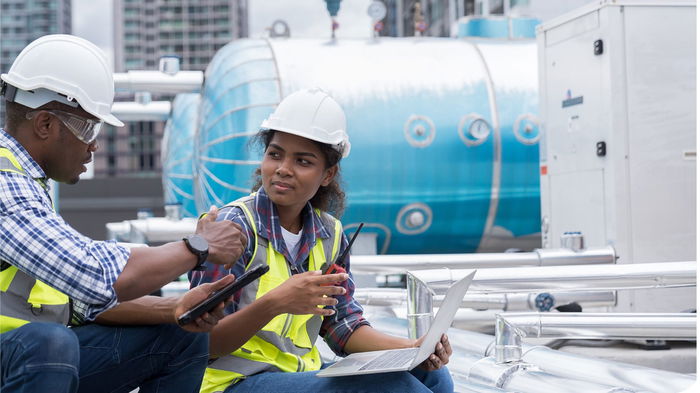 Two construction workers looking at each other at a site