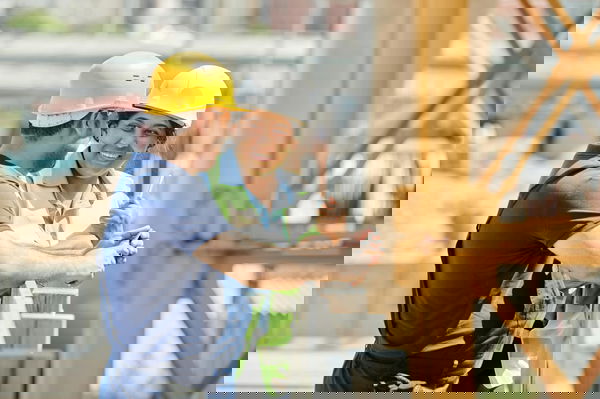 A Man and Woman Wearing Hard Hat While Talking